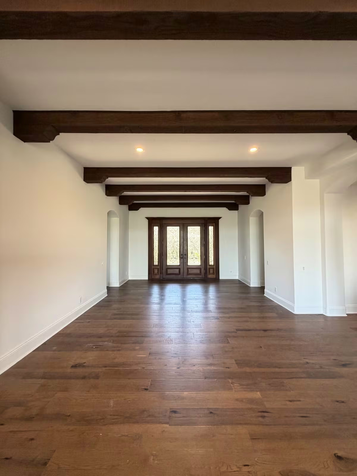 Great room with wood beam ceiling and French doors after painting