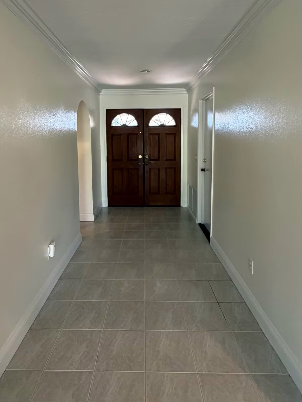 Entry hallway with front doors and tile floor after interior painting
