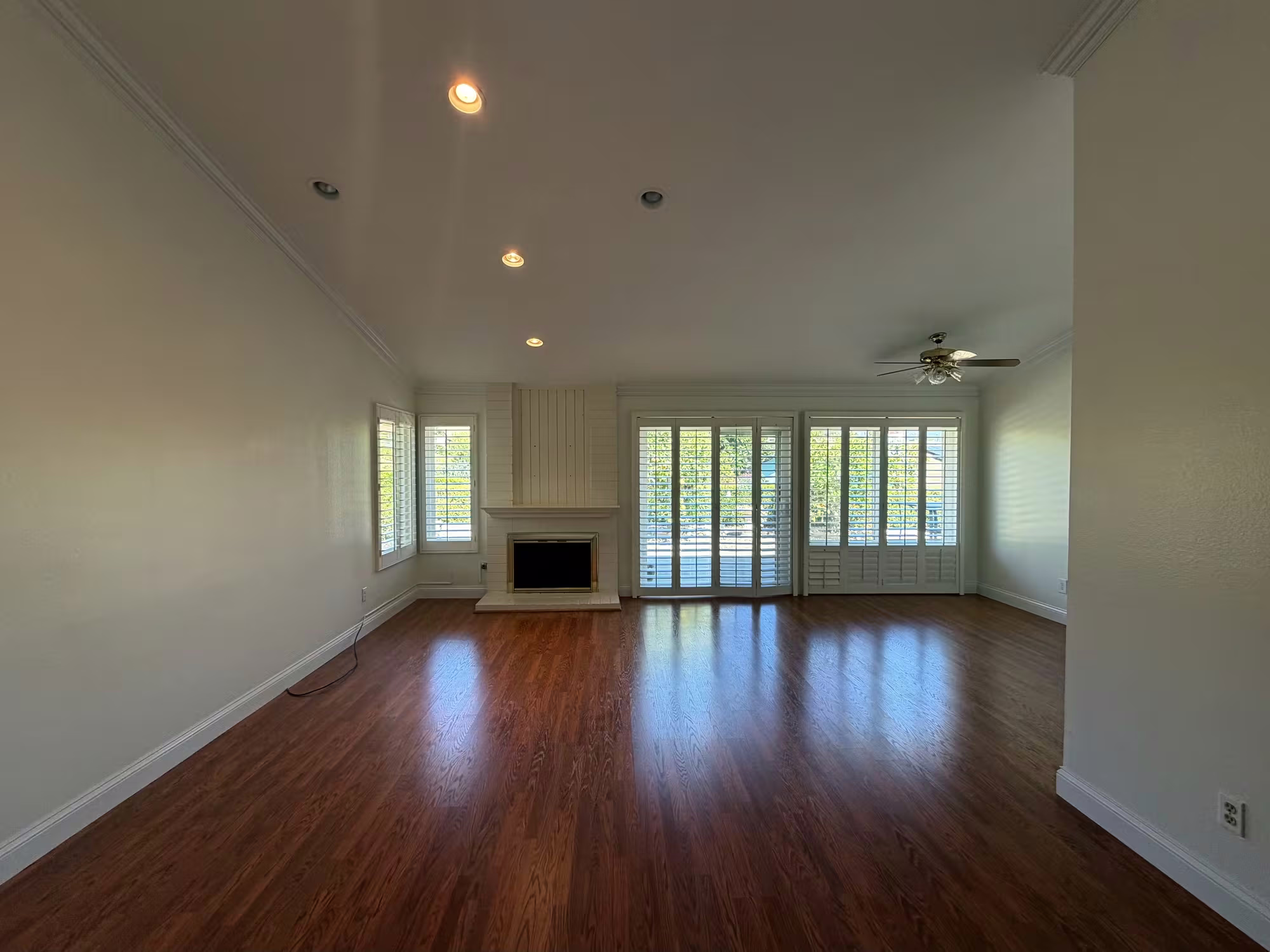 Great room with fireplace and ceiling fan after painting